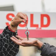 Hand placing house key in another person's hand