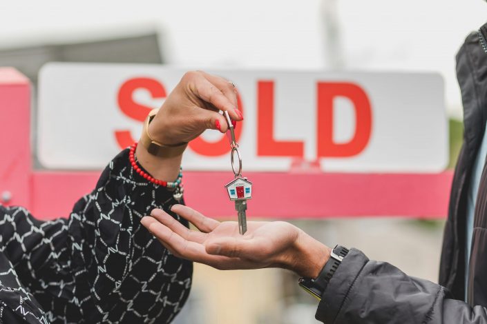 Hand placing house key in another person's hand